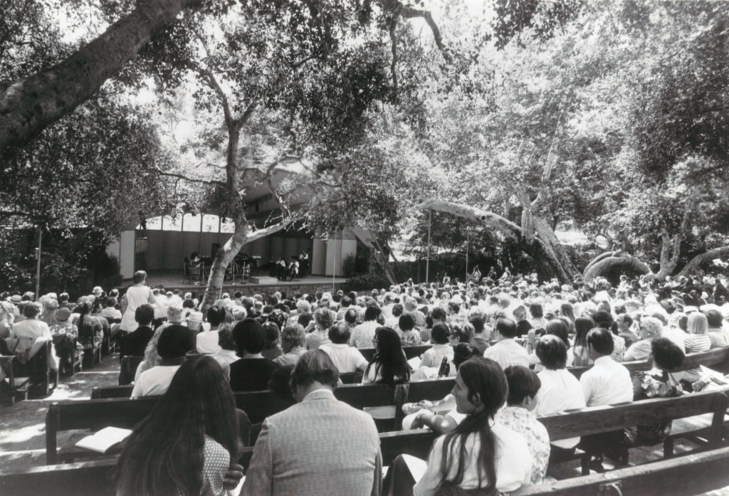 black and white film image of an audience seated outdoors