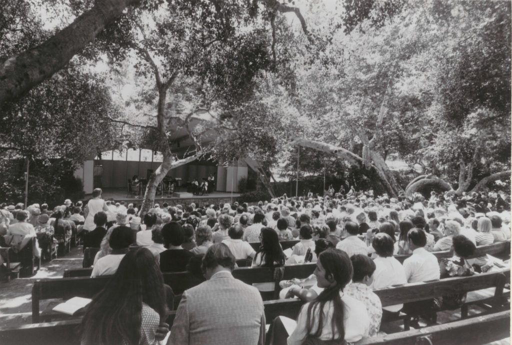 black and white film photo of an audience seated outdoors